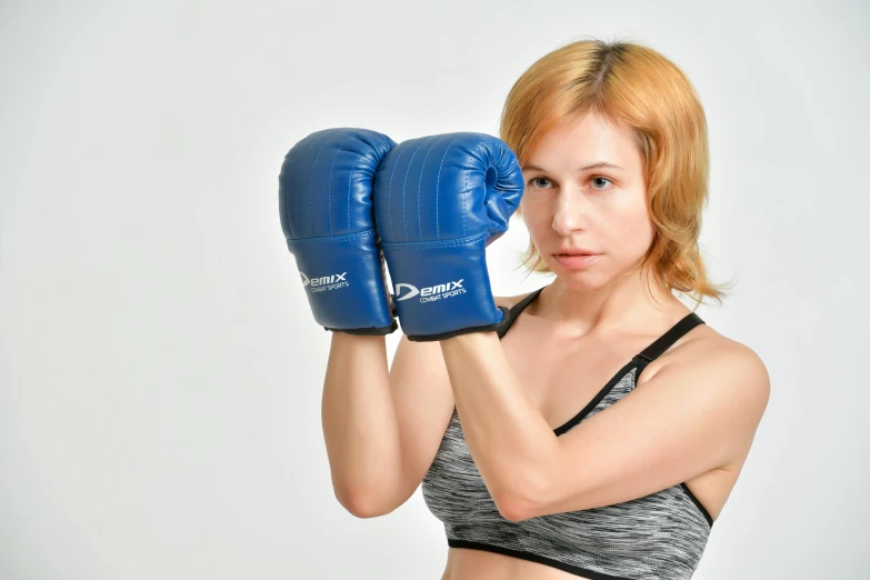 a woman in a sports bra top and boxing gloves, inspired by Daryush Shokof, pexels contest winner, blue, attack pose, mid 2 0's female, rectangle