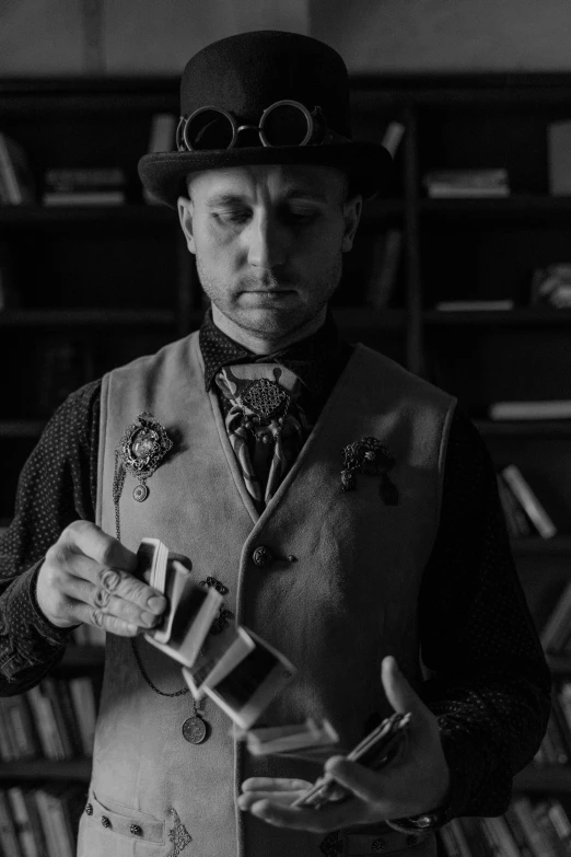 a black and white photo of a man in a top hat and vest, unsplash, kinetic art, holding grimoire, the card player man, looking serious, portrait of machine man