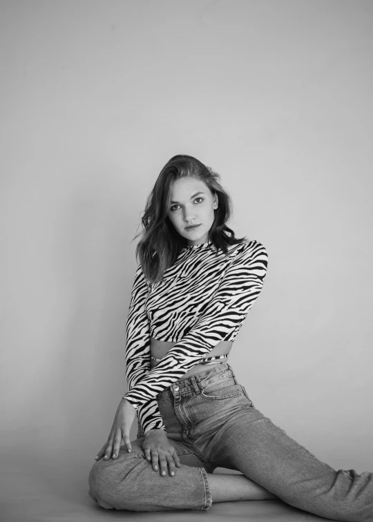 a black and white photo of a woman sitting on the floor, by Emma Andijewska, unsplash contest winner, op art, portrait of barbara palvin, jeans, patterned clothing, headshot profile picture