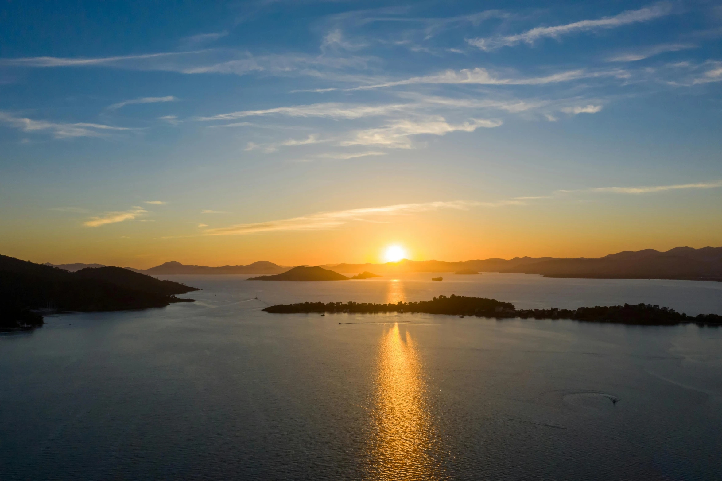 the sun is setting over a body of water, by Niko Henrichon, pexels contest winner, islands, golden hour 8 k, a high angle shot, new zealand