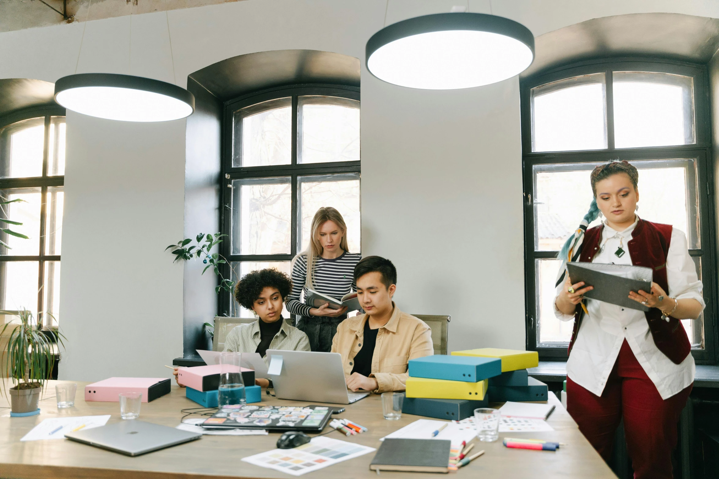 a group of people sitting around a table with laptops, trending on pexels, arbeitsrat für kunst, standing on a desk, avatar image