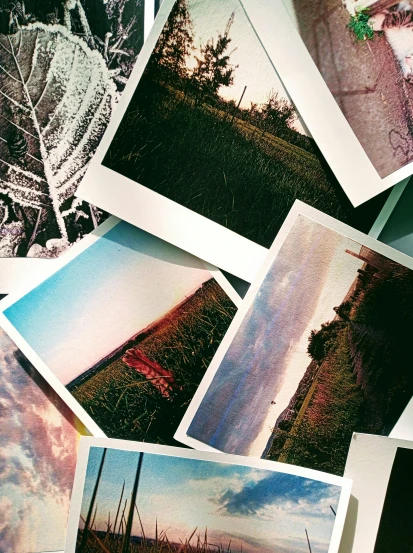 a bunch of pictures sitting on top of a table, washed out colors, fields, cracked and faded photo paper, trending photo