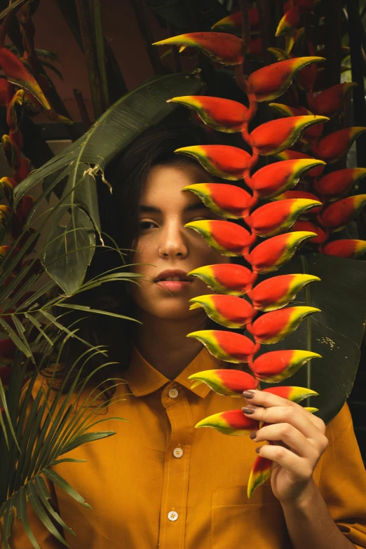 a woman holding a flower in front of her face, an album cover, inspired by Elsa Bleda, pexels contest winner, tropical birds, the yellow creeper, big leaves, !!! colored photography