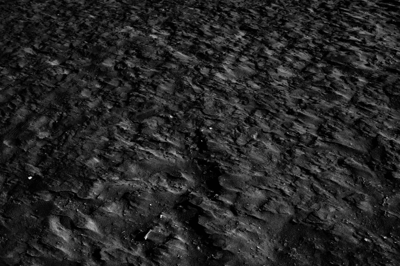 a black and white photo of a beach, a black and white photo, by Andor Basch, digital art, moon surface background, brown mud, paved, glare