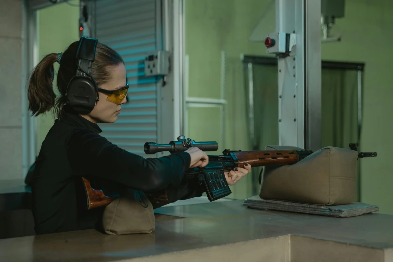 a woman wearing headphones and holding a rifle, gunsmithing, game ready, indoor shot, high accuracy