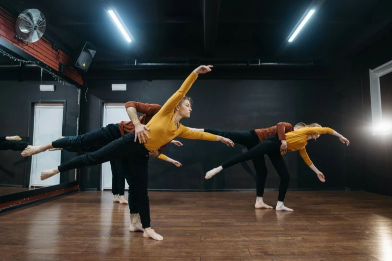 a group of dancers performing in a dance studio, by Emma Andijewska, unsplash, arabesque, zero gravity, 3 / 4 pose, modest, trio