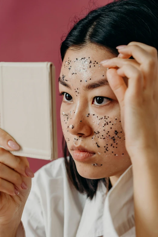 a woman taking a selfie in front of a mirror, an album cover, trending on pexels, mingei, black tar particles, peeling face skin, asian, made of dots