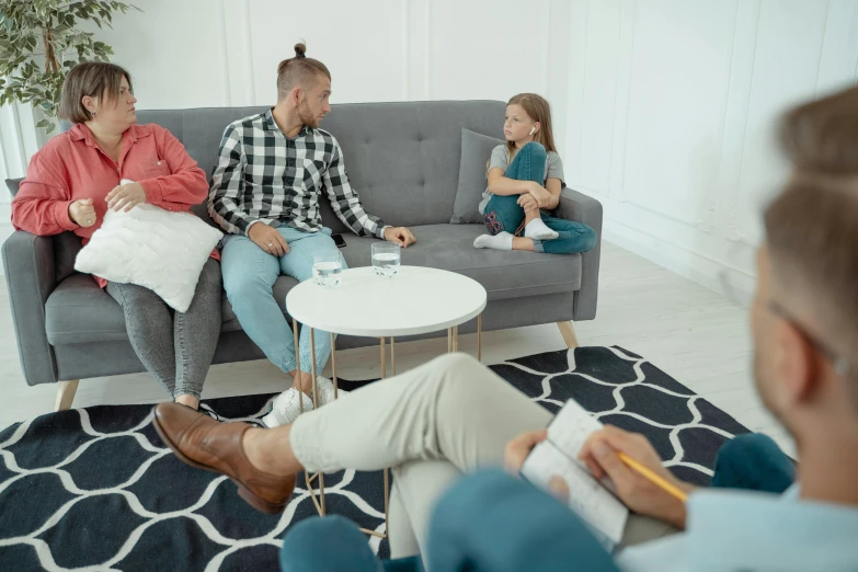 a group of people sitting on a couch in a living room, on a white table, fatherly, hypnosis, high quality upload