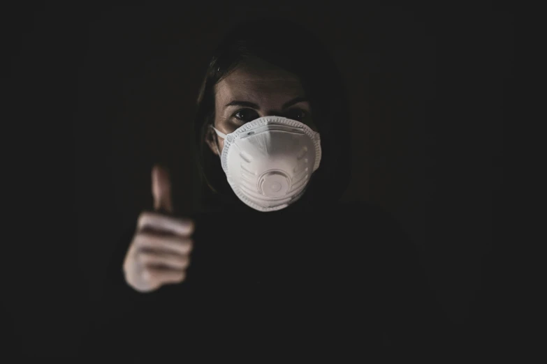 a woman wearing a face mask giving a thumbs up, by Adam Marczyński, pexels contest winner, dark and dusty, scp-049, avatar image, instagram picture