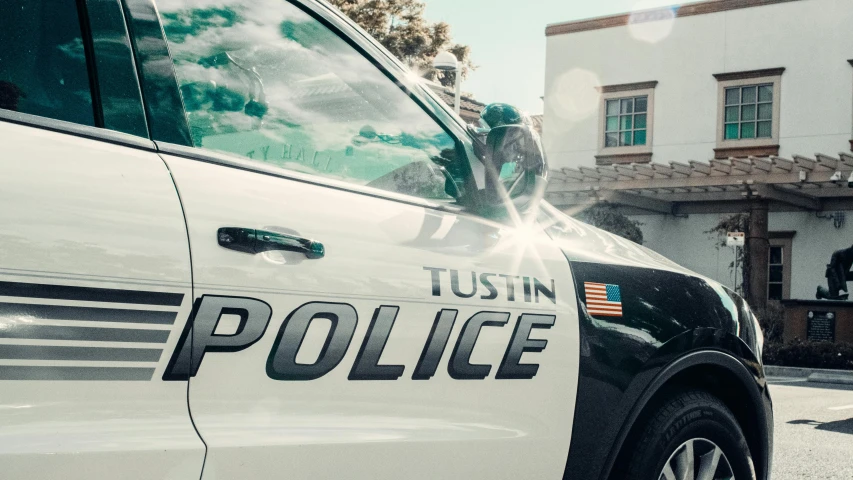a police car parked in front of a building, by Terese Nielsen, trending on unsplash, nipsey hussle, 2 5 6 x 2 5 6 pixels, puttin, tungsten