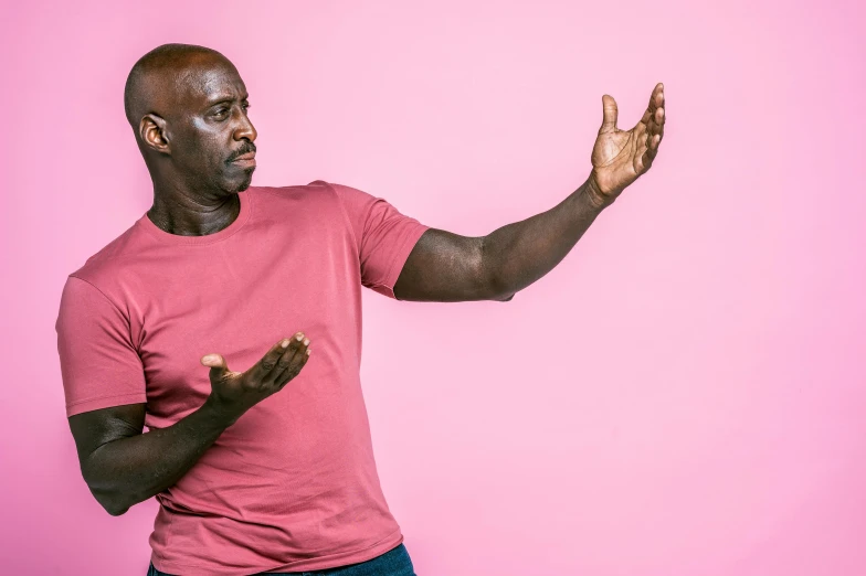 a man in a pink shirt is holding his hands up, by Joseph Severn, pexels contest winner, lance reddick, plain background, arguing, profile image