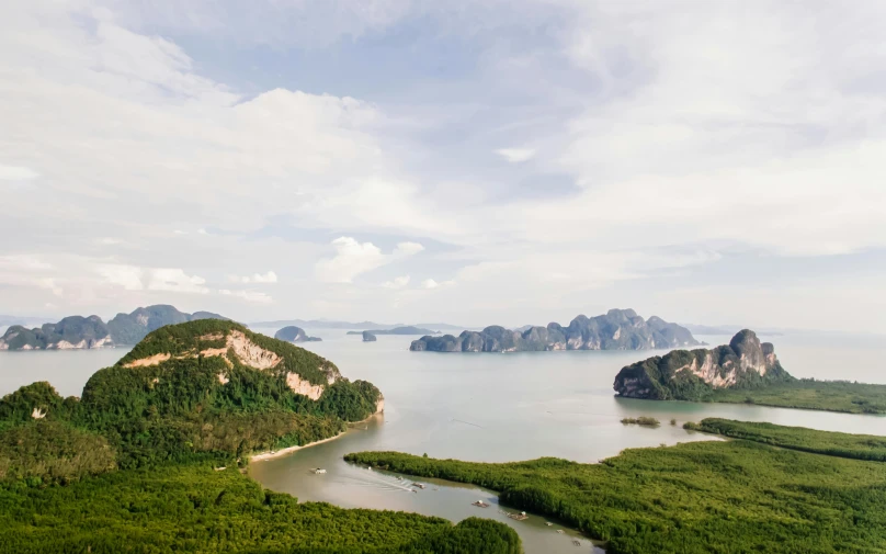 a large body of water next to a lush green hillside, pexels contest winner, thailand, flying islands, flat lay, grey