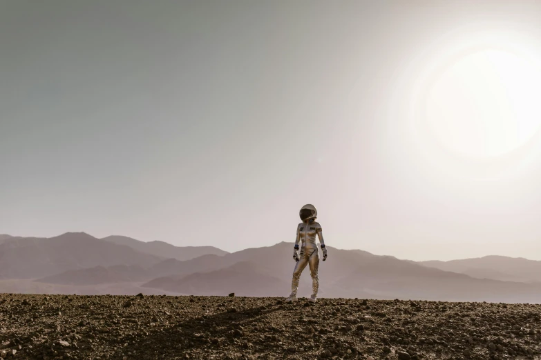 a man standing on top of a dirt field, inspired by Scott Listfield, pexels contest winner, afrofuturism, beautiful woman in spacesuit, mars one mission, photo still of, interstellar movie