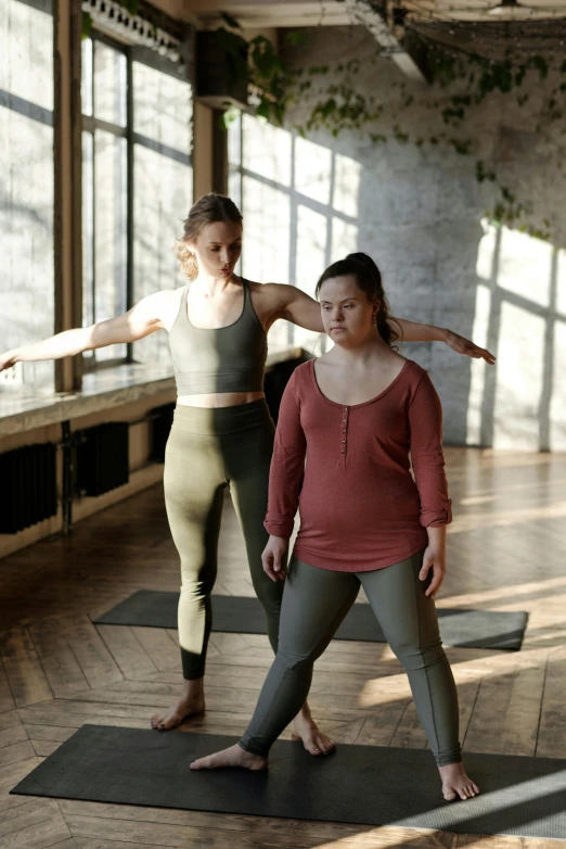 a couple of women standing on top of yoga mats, by Nina Hamnett, trending on pexels, renaissance, plus-sized, square, low quality photo, brown