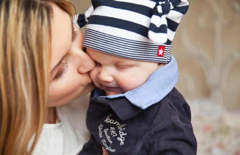 a woman kissing a baby wearing a hat, pexels, breton cap, navy, high quality print, striped