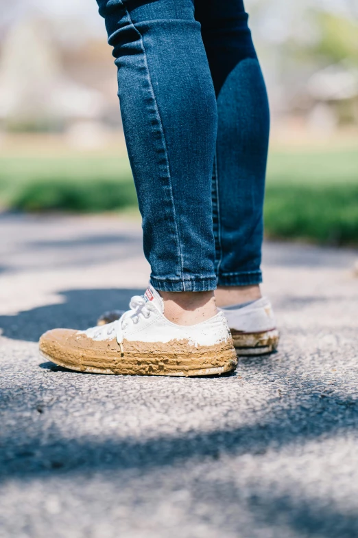 a woman standing on top of a sidewalk next to a dog, by Nina Hamnett, trending on unsplash, gum rubber outsole, covered in dirt, on white background, bumps
