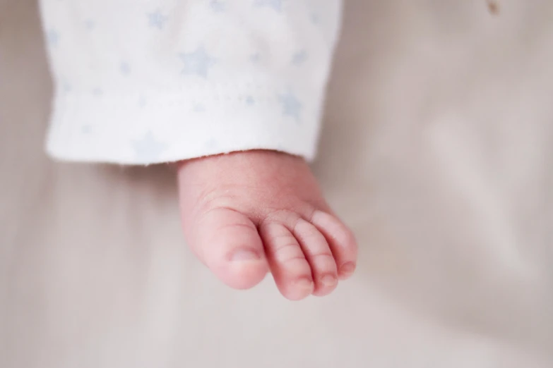 a close up of a baby's feet in a crib, by Ruth Simpson, stars, soft grey and blue natural light, hand model, detail shot