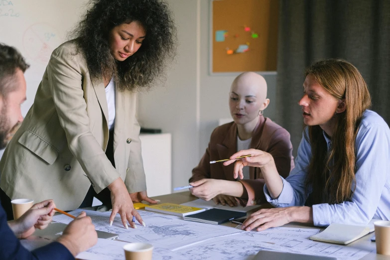 a group of people sitting around a table, on a desk, insipiring, a woman, charts