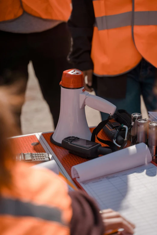 a group of people standing around a table, orange electricity, hasselblade wide shot, holding flask in hand, worksafe