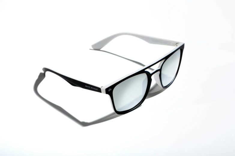 a pair of sunglasses sitting on top of a white surface, inspired by Patrick Pietropoli, polarized lens, ( side ) profile, black & white, sharper luminescent focus