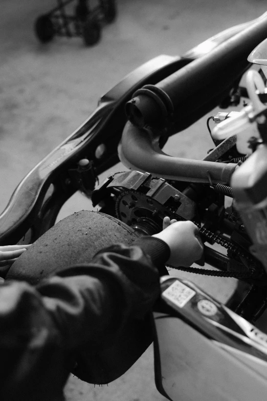 a black and white photo of a person on a motorcycle, a black and white photo, unsplash, conceptual art, mechanical hands, uploaded, instrument, holga
