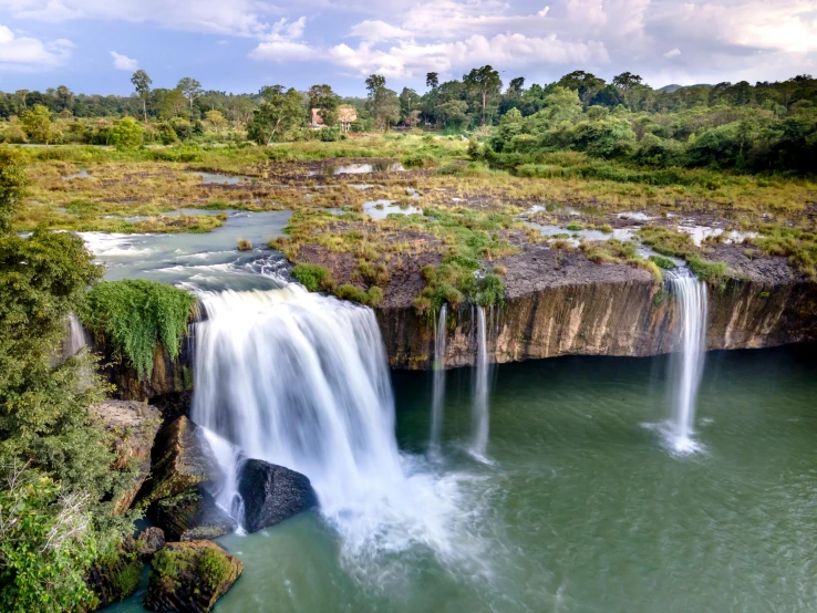 a waterfall in the middle of a lush green field, hurufiyya, in an african river, slide show, multiple stories, gray