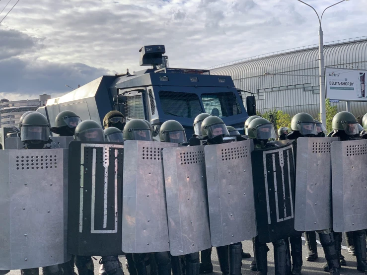 a group of police officers standing in front of a truck, by Alejandro Obregón, reddit, hurufiyya, riot shields, neo norilsk, background image, blocking the sun