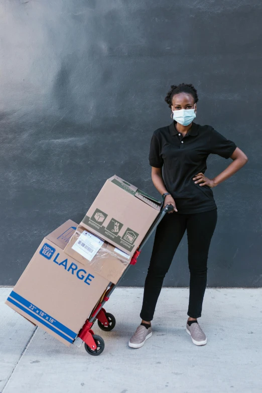 a woman standing next to a cart with boxes on it, pexels contest winner, renaissance, wearing facemask, african american woman, gigantic size, leg high