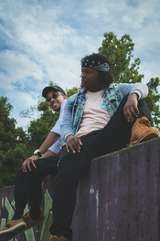 a couple of men sitting on top of a skateboard ramp, an album cover, unsplash, ( ( dark skin ) ), looking off to the side, next to a tree, profile image