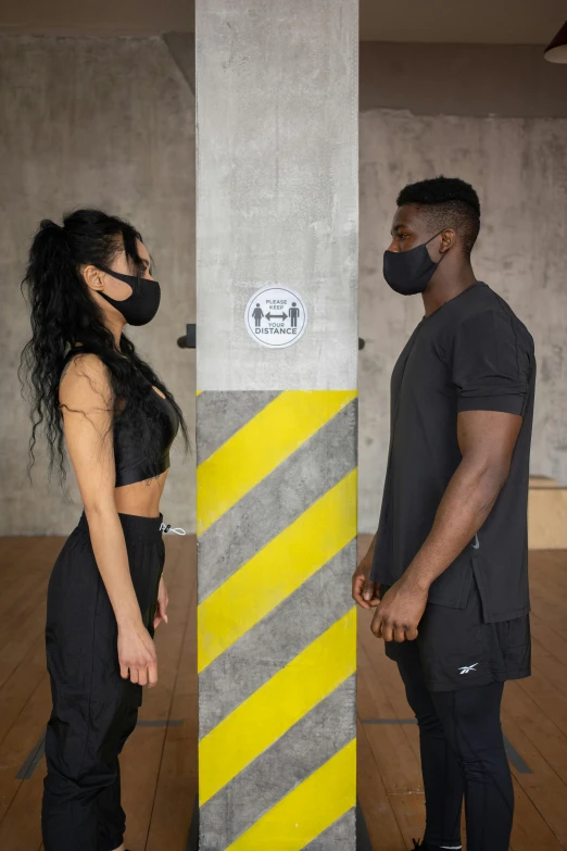 a man and a woman standing next to each other, black facemask, wearing fitness gear, off - white collection, facing each other