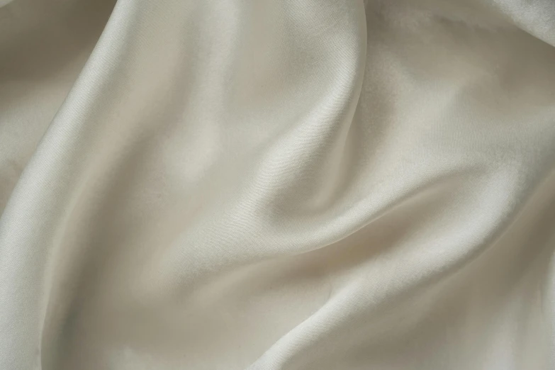 a close up view of a white fabric, by David Simpson, unsplash, silver，ivory, satin silver, light tan, highly polished