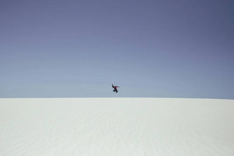 a man flying through the air while riding a snowboard, inspired by Scarlett Hooft Graafland, unsplash contest winner, minimalism, white sand, hq 4k phone wallpaper, new mexico, 8k hq