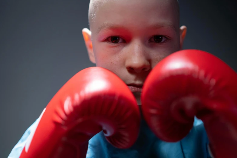 a close up of a person wearing boxing gloves, pexels contest winner, antipodeans, a bald, young boy, eleven/millie bobbie brown, battling demons