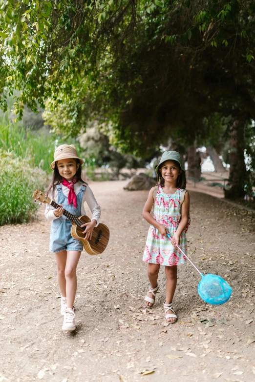 a couple of young girls walking down a dirt road, inspired by Elsa Beskow, unsplash, musical instruments, at a park, bay area, kids playing