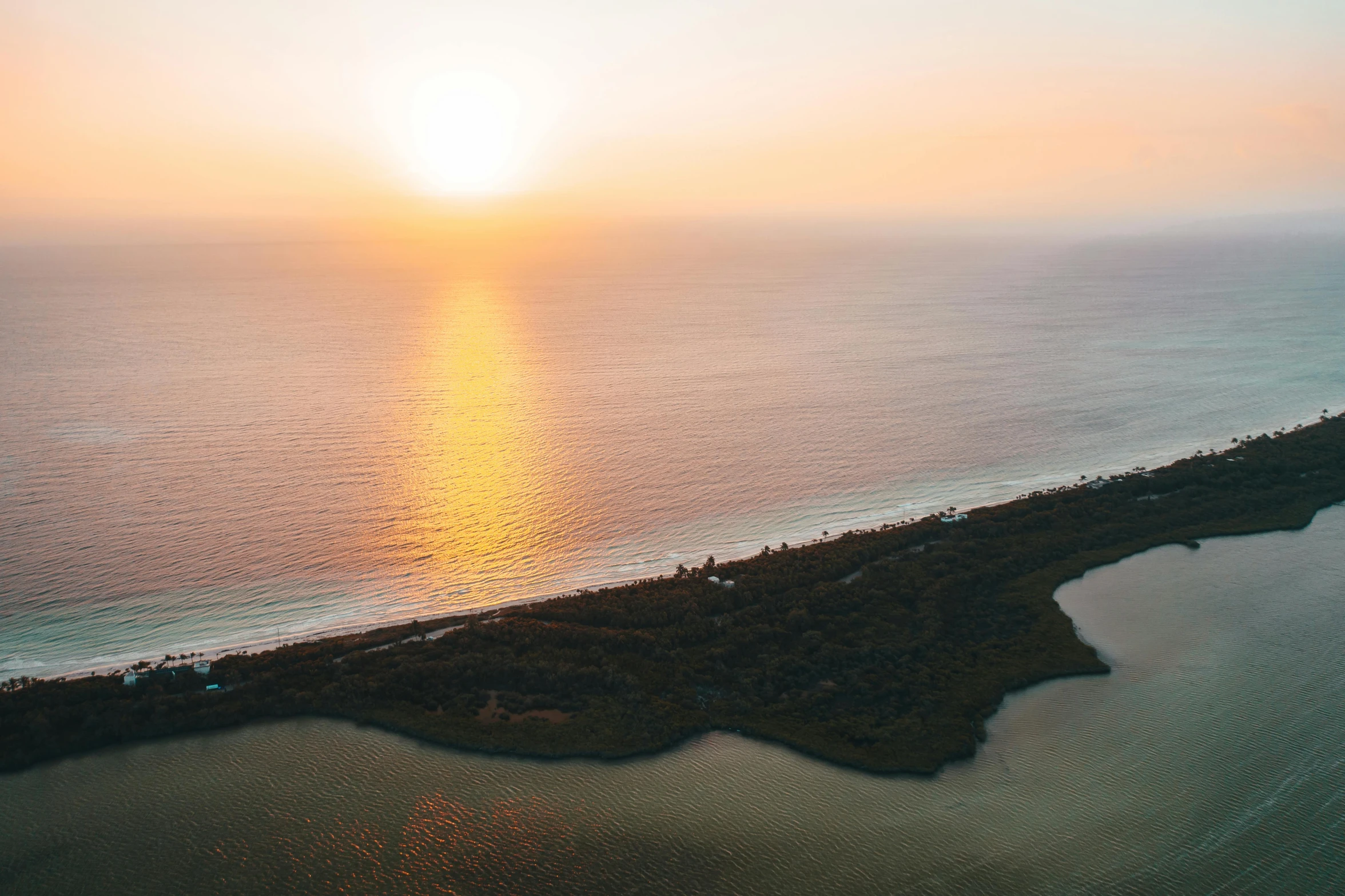 a large body of water next to a beach, a picture, by Daniel Lieske, unsplash contest winner, australian tonalism, golden hour 4k, bird view, on an island, sunset panorama