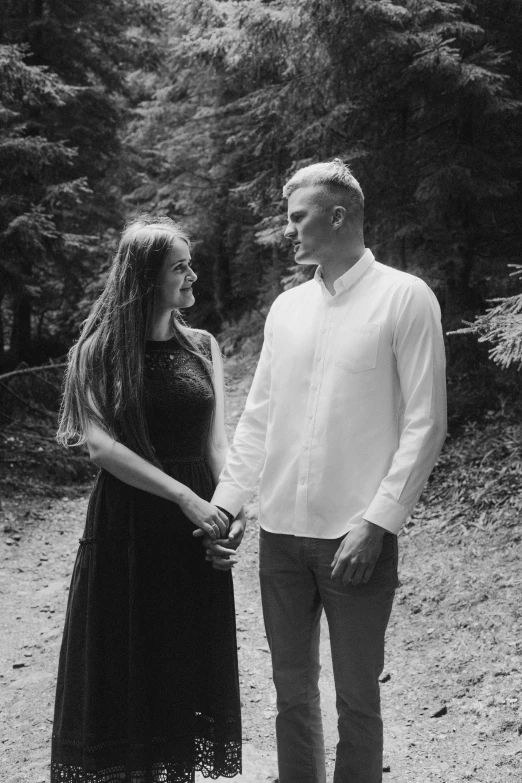 a man and woman standing next to each other on a dirt road, a black and white photo, unsplash, in beautiful woods, around 20 yo, barabas miklos and hollosy simon, 🌸 🌼 💮