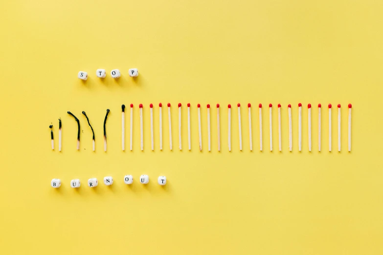 a number of matches on a yellow background, by Julia Pishtar, minimalism, contracept, artistic composition, aftermath, stick and poke