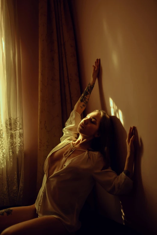 a woman leaning against a wall next to a window, inspired by Elsa Bleda, art photography, laying on a bed, arms outstretched, magic hour lighting, in the astral plane ) ) )