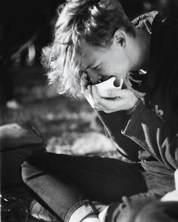 a black and white photo of a person sitting on the ground, by Bert Hardy, crying one single tear, jamie campbell bower, picnic, digital image