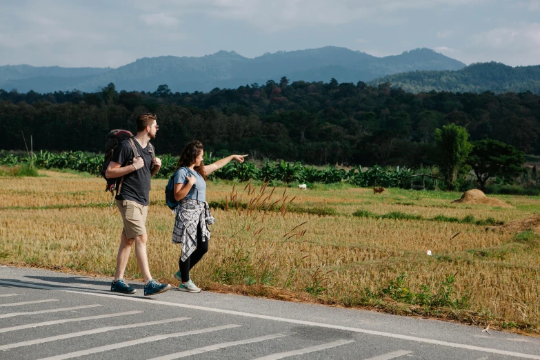 a couple of people standing on the side of a road, happening, exploring new friendly lands, promo image, thumbnail, high quality image