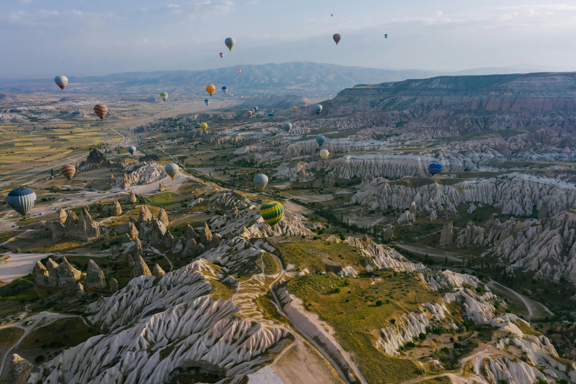 a group of hot air balloons flying over a valley, by irakli nadar, pexels contest winner, white travertine terraces, subtitles, thumbnail, 90s photo