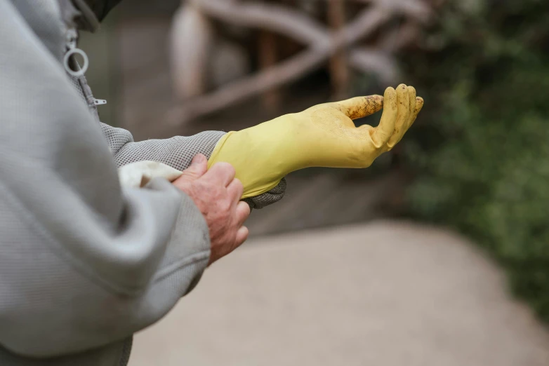 a close up of a person holding a banana, inspired by Sarah Lucas, wearing gloves, flexiseal, ochre, angled shot