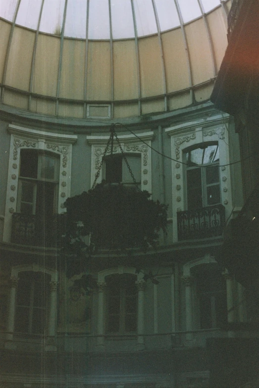 a clock hanging from the ceiling of a building, a polaroid photo, inspired by Elsa Bleda, tumblr contest winner, neoclassicism, domes, mysterious exterior, low quality photo, green house