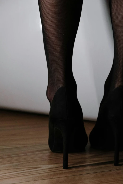 a close up of a person wearing high heels, black on black, velvet stockings, rear-shot, close up half body shot