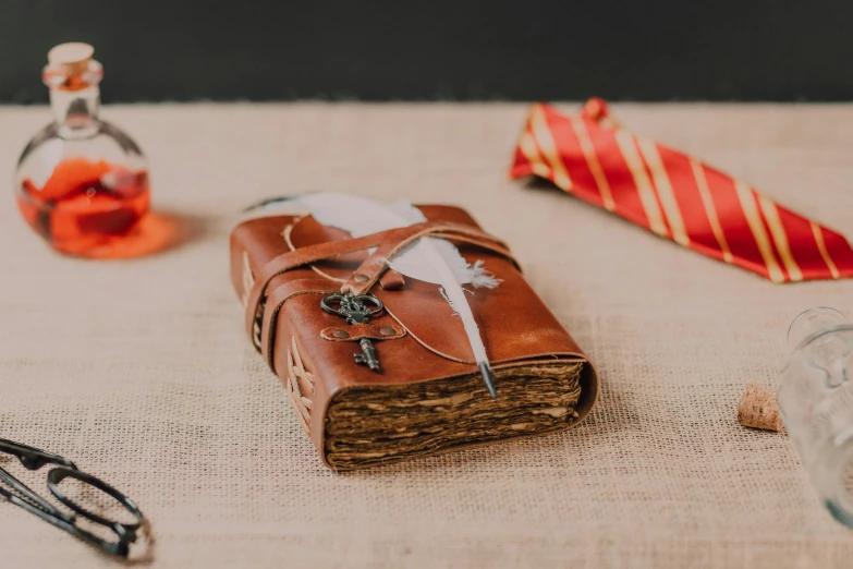 a book sitting on top of a table next to a pair of scissors, wizard themed, leather pouch, thumbnail, photoshoot