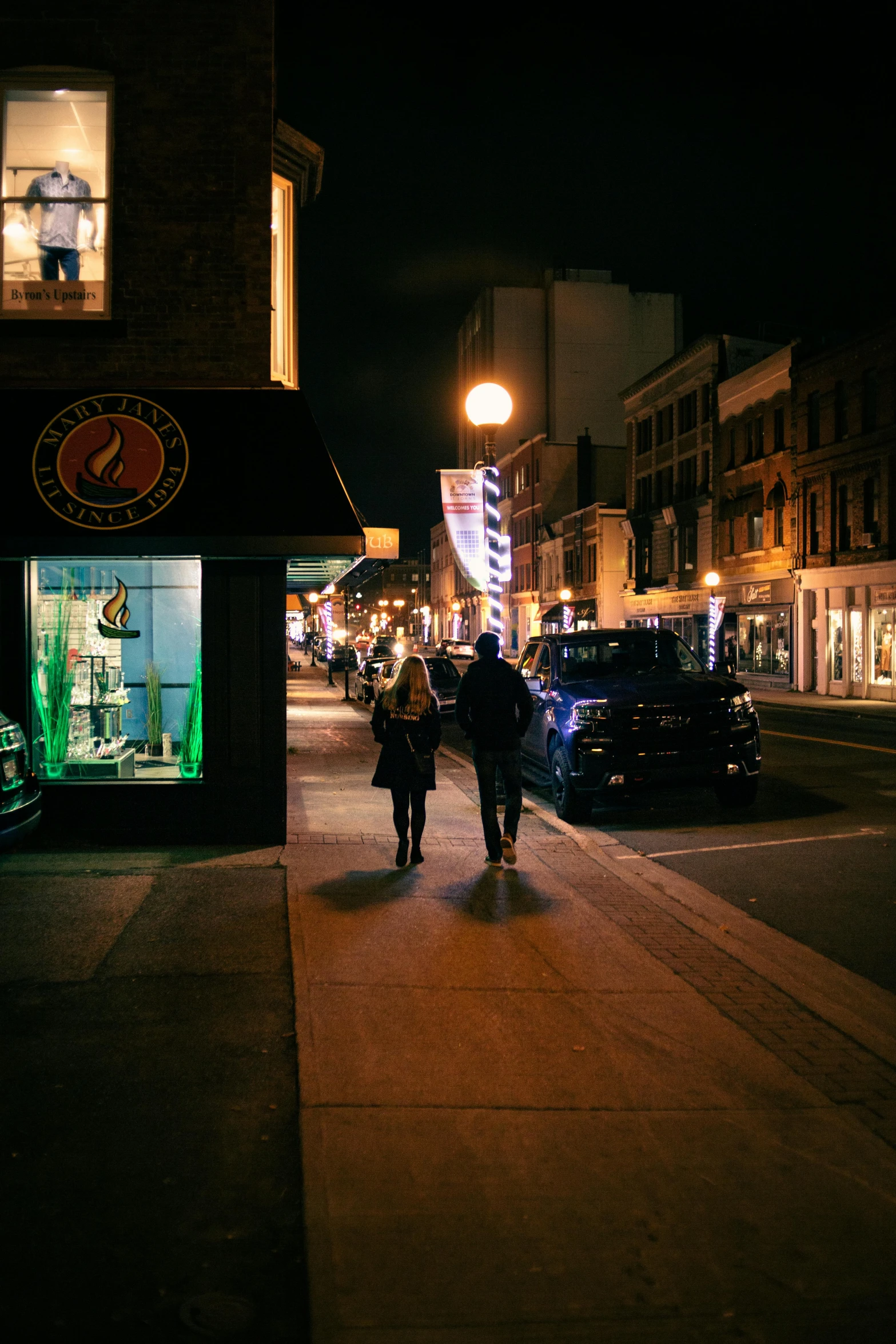 two people walking down a city street at night, new hampshire, fan favorite, stores, 2019 trending photo