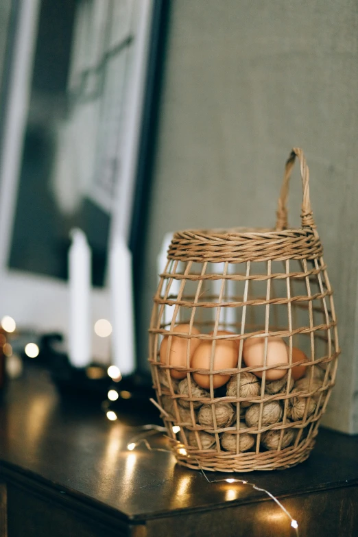 a basket filled with eggs sitting on top of a table, by Jan Tengnagel, pexels contest winner, renaissance, lantern candle, scandinavian design, jar on a shelf, string lights