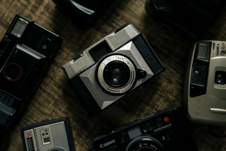 a group of cameras sitting on top of a table, unsplash contest winner, photorealism, cinematic diane arbus, high angle close up shot, shot with sigma f/ 4.2, icon