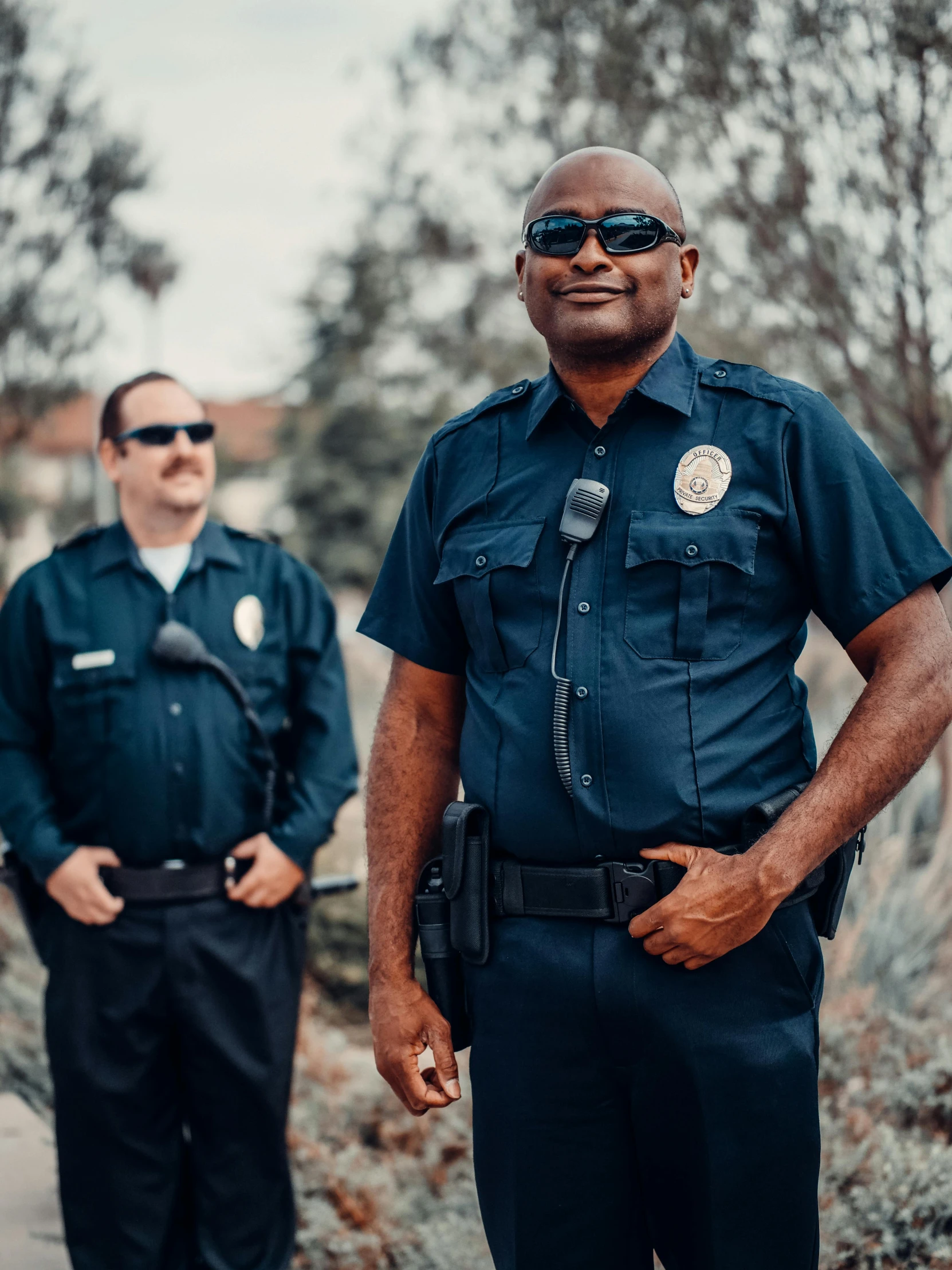 two police officers standing next to each other, trending on unsplash, background image, 🚿🗝📝, low quality photo, bandoliers