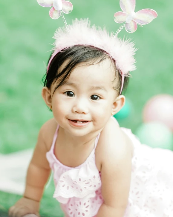 a baby girl wearing a pink dress and butterfly headband, inspired by Marie Angel, pexels contest winner, young cute wan asian face, celebration, wearing spiky, grinning lasciviously